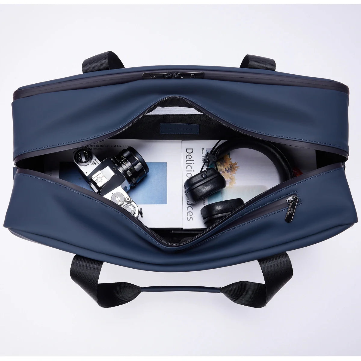 The best gym duffle bags for men with spacious interior storing camera, magazines, and headphones, perfect for creatives on the go.